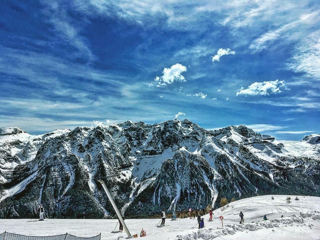 Paesaggio montano della Val di Sole in Trentino con prati e vette alpine