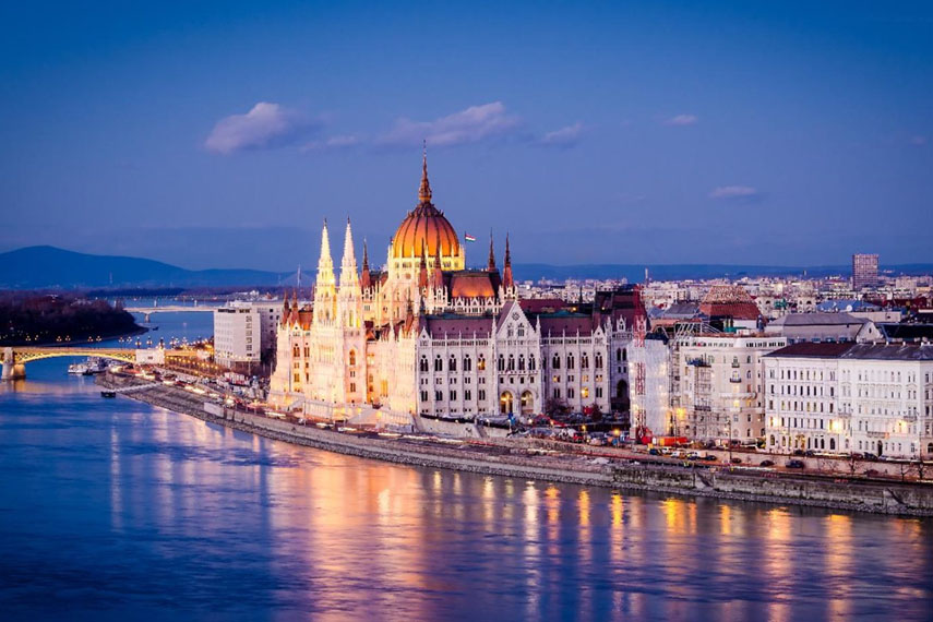 Veduta panoramica di una capitale europea con palazzi storici e fiume al tramonto