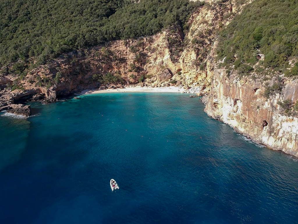 Baia con acqua cristallina e calette di sabbia chiara lungo la costa della Sardegna