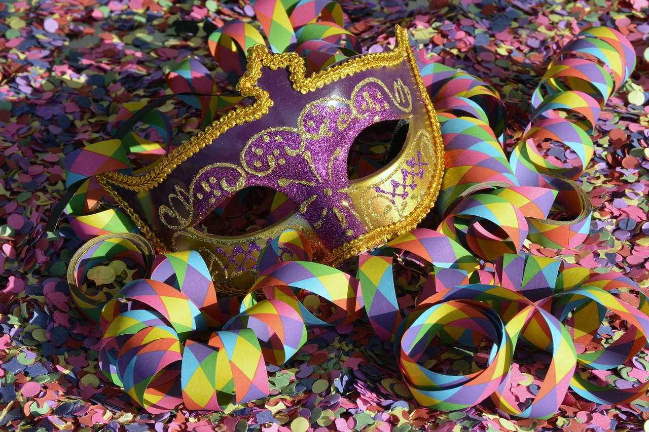 Maschere e coriandoli colorati durante i festeggiamenti del Carnevale in una piazza italiana